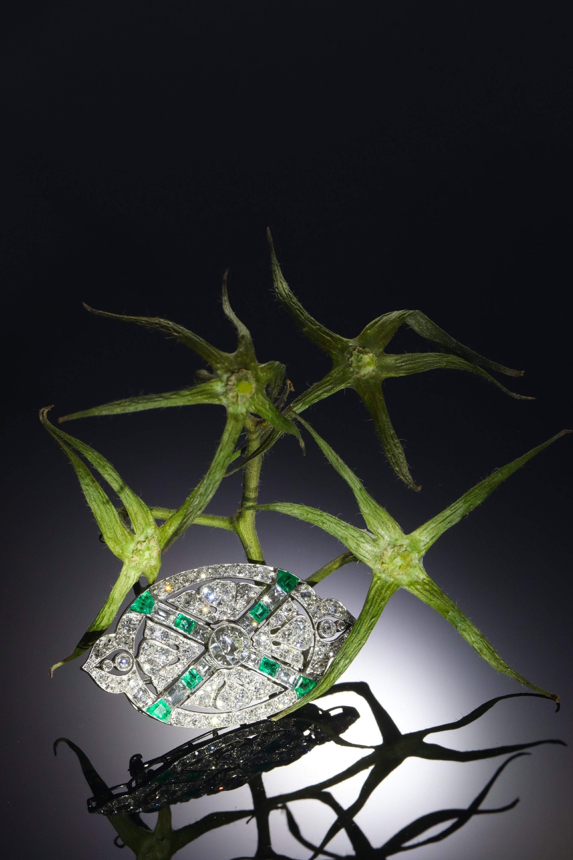 Click the picture to see of this Art Deco platinum diamond and emerald brooch with almost 7.00 crts of total diamond weight